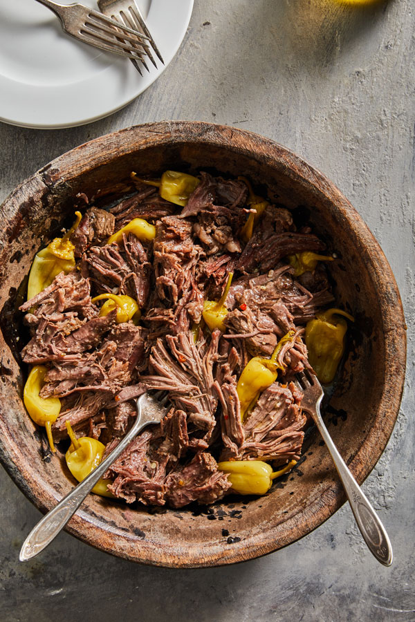 Shredded Pot Roast in a bowl with pepperoncini peppers